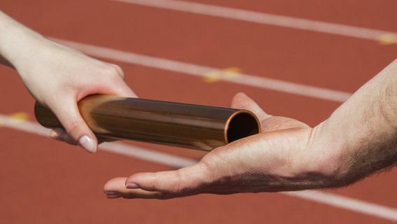 Staffelstab-Läufer-Übergabe Übergabe eines Staffelstabs