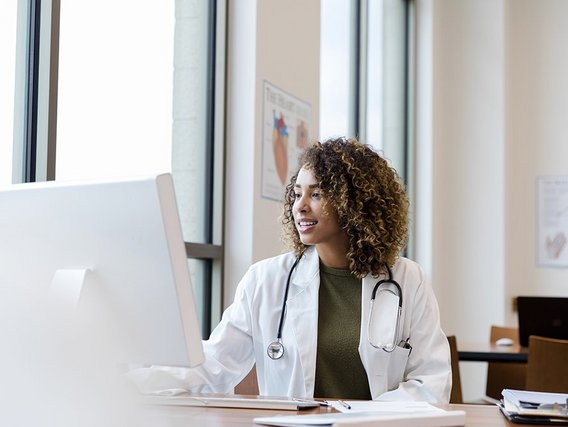 Ärztin am Schreibtisch vor dem Bildschirm Ärztin am Schreibtisch vor dem Bildschirm