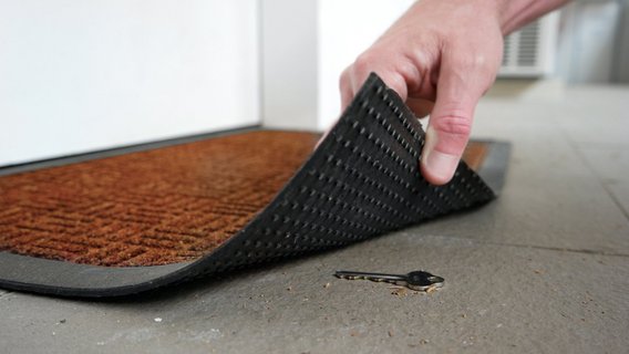 Schlüssel-Fußmatte Schlüssel unter einer Füßmatte