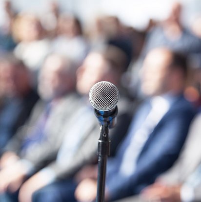 Mikrofon vor Veranstaltungsteilnehmenden Mikrofon vor Veranstaltungsteilnehmenden